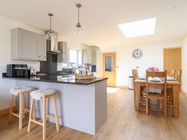 A kitchen with a dining table and stools at Bryn Bras in Corwen
