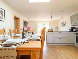 A kitchen with a dining area and a table set with plates at Bryn Bras in Corwen