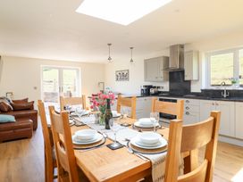 A kitchen with a dining area and kitchen appliances at Bryn Bras in Corwen