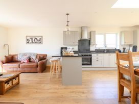 A kitchen with a sofa and dining table at Bryn Bras in Corwen