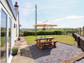 A garden with a picnic table and umbrella at Bryn Bras in Corwen