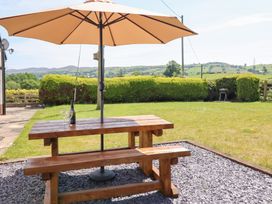A garden with a table and umbrella at Bryn Bras in Corwen