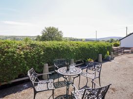 An outdoor seating area with a table and chairs at Bryn Bras Corwen