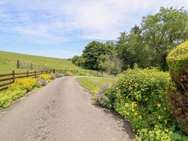 A winding road surrounded by flowers and trees at Bryn Bras in Corwen