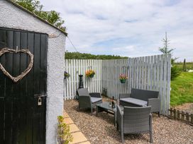 An outdoor seating area with patio furniture and hanging plants at High Wreah Bolt Hole Cleator Moor