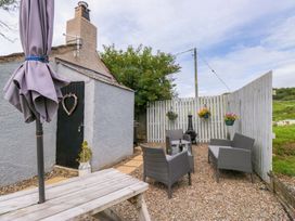 An outdoor seating area with a table and chairs at High Wreah Bolt Hole in Cleator Moor