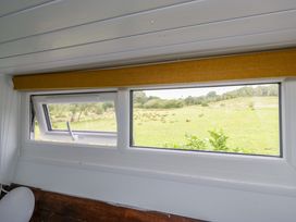 A window with a view of a grassy area at High Wreah Bolt Hole in Cleator Moor
