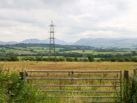A view of fields and mountains with a power line at High Wreah Bolt Hole in Cleator Moor
