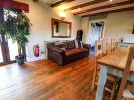 A dining room with a sofa and dining table at Home Farm St Asaph