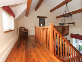 A landing area with wooden flooring and a chair at Home Farm St Asaph