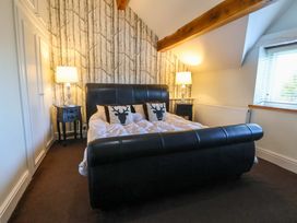 A bedroom with a large bed and bedside lamps at Home Farm St Asaph