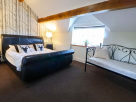 A bedroom with a bed and a sofa at Home Farm St Asaph