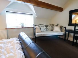 A bedroom with a bed and a sofa next to a window at Home Farm St Asaph