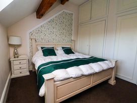 A bedroom with a bed and a bedside table at Home Farm St Asaph