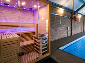 A sauna adjacent to a swimming pool at Home Farm St Asaph