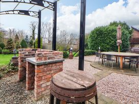 A garden with a barbecue grill and seating area at Home Farm St Asaph