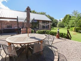 An outdoor area with a round table and umbrella at Home Farm St Asaph