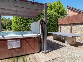 An outdoor area with a hot tub and a table tennis table at Home Farm St Asaph