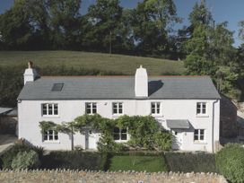 An exterior view of a house with a garden at Lower Well Farm House in Totnes