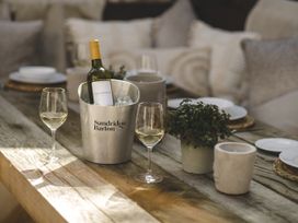 A dining area with wine and glasses at Lower Well Farm House in Totnes