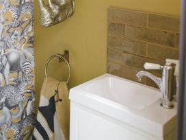 A washbasin with a faucet in a bathroom at Lower Well Farm House in Totnes