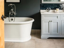 A bathroom with a bathtub and sink at Lower Well Farm House in Totnes