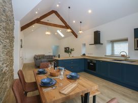 A kitchen with a dining table and chairs at Beudy