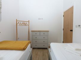 A bedroom with a bed, dresser, and wardrobe at Beudy