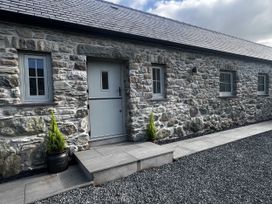 An outdoor area with a stone wall and steps at Beudy Tanrallt in Llanfachraeth