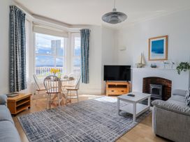 A living room with a sofa and dining area at Sea Lovers in Exmouth