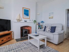 A living room with a sofa and television at Sea Lovers in Exmouth