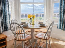 A dining room with a round table and chairs at Sea Lovers in Exmouth