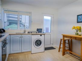 A kitchen with a washing machine and table at Sea Lovers in Exmouth