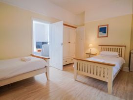 A bedroom with two beds, a nightstand and a wardrobe at Sea Lovers in Exmouth