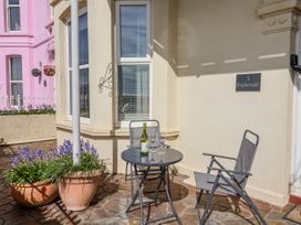 An outdoor seating area with a table and chairs at Sea Lovers in Exmouth