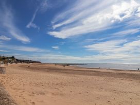 A beach with people walking at Sea Lovers in Exmouth