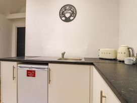 A kitchen countertop with a sink a toaster a kettle and a small refrigerator underneath at Kingfisher Cottage in Ottinge near Lyminge