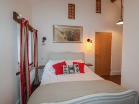 A bedroom with a bed pillows and a painting above it at The Old Parlour in Cwm near Dyserth