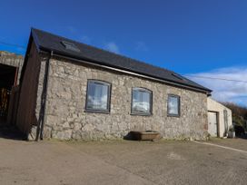 An exterior view of a stone building with three windows and a sloped roof at The Old Parlour in Cwm near Dyserth