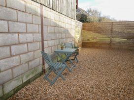 An outdoor seating area with two chairs and a small table on gravel at The Old Parlour in Cwm near Dyserth