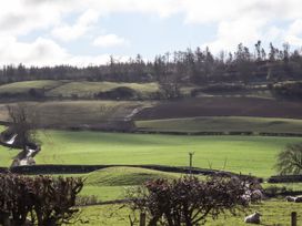 A rural landscape with green fields trees and sheep at The Old Parlour in Cwm near Dyserth
