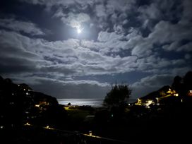 A night view of the ocean with moonlight and clouds at Shells Cottage in Looe