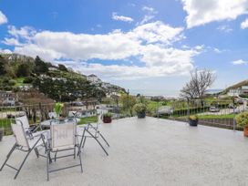 An outdoor terrace with seating and a view of the sea at Shells Cottage in Looe
