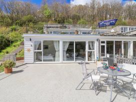 An outdoor dining area with a table and chairs at Shells Cottage in Looe