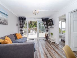 A living room with a sofa and television at Shells Cottage in Looe