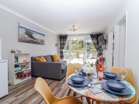 A living room with a dining table and sofa at Shells Cottage in Looe