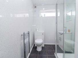 A bathroom featuring a shower, toilet, and sink at Shells Cottage in Looe