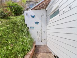 An outdoor area with a shower and decorative butterflies at Shells Cottage in Looe
