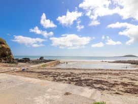 A beach scene with a view of the sea and a pier at Shells Cottage in Looe