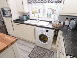 A kitchen with a washing machine and sink at A and C Lodge-Plot 21 Armathwaite